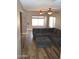 Spacious living room with wood-look tile flooring and comfortable, over-sized, sectional sofa at 13486 W Evans Dr, Surprise, AZ 85379