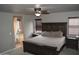 Comfortable bedroom featuring a king-size bed, ceiling fan, and attached bathroom with a soaking tub at 13486 W Evans Dr, Surprise, AZ 85379