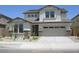 View of a two-story home with stone accents, a two-car garage, and a well-maintained front yard at 14150 W Boca Raton Rd, Surprise, AZ 85379