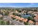 An aerial view of a residential area with tile roofs, lush trees, and a beautiful lake enhancing the scenery at 1558 W Maplewood St, Chandler, AZ 85286