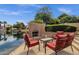 Charming outdoor area with a fireplace, seating, and lake views, perfect for relaxing and enjoying the scenery at 1558 W Maplewood St, Chandler, AZ 85286