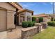 Inviting home entrance with stone accents, mature green landscaping, and a charming terracotta-tiled roof at 1558 W Maplewood St, Chandler, AZ 85286
