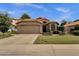 A well-maintained home boasts lush landscaping, terracotta tile roofing, and a welcoming two-car garage at 1558 W Maplewood St, Chandler, AZ 85286