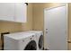 Convenient laundry room with modern washer and dryer, overhead cabinets and access to the garage at 1558 W Maplewood St, Chandler, AZ 85286