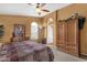 Spacious primary bedroom with ceiling fan, natural light from windows and a door leading to the ensuite bathroom at 1558 W Maplewood St, Chandler, AZ 85286