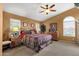 Comfortable primary bedroom with ceiling fan, dresser, side tables and natural light from the windows at 1558 W Maplewood St, Chandler, AZ 85286
