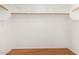 Walk-in closet featuring white walls, built-in shelving, and a wooden rod at 15980 W Smokey Dr, Surprise, AZ 85374