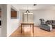 Open dining area with hardwood flooring, a wooden table, and a view into the living room at 15980 W Smokey Dr, Surprise, AZ 85374