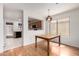 Bright dining area with hardwood floors and modern lighting, adjoining the kitchen at 15980 W Smokey Dr, Surprise, AZ 85374