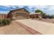 Exterior view of a home with a two-car garage and long driveway at 15980 W Smokey Dr, Surprise, AZ 85374