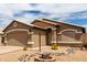 Single-story home with a two-car garage, desert landscaping, and rock accents at 15980 W Smokey Dr, Surprise, AZ 85374