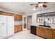 Bright kitchen has oak cabinets, white countertops, black appliances, and white refrigerator at 15980 W Smokey Dr, Surprise, AZ 85374