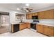 Bright kitchen features oak cabinets, white countertops, black appliances, and tile flooring at 15980 W Smokey Dr, Surprise, AZ 85374