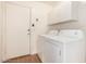 Clean laundry area with washer, dryer, white storage cabinets, and direct outdoor access at 15980 W Smokey Dr, Surprise, AZ 85374
