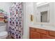 Clean bathroom featuring a shower, vanity, and convenient shelving for storage with patterned curtain at 16602 N 25Th St # 204, Phoenix, AZ 85032
