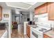 Open kitchen with wood cabinets and white appliances, seamlessly flowing into the living area with patio access at 16602 N 25Th St # 204, Phoenix, AZ 85032