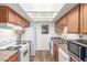 Well-lit kitchen featuring wood cabinets, white appliances, and a skylight providing natural light at 16602 N 25Th St # 204, Phoenix, AZ 85032