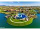 Aerial view of community amenities including a resort style pool and clubhouse surrounded by a lake at 17111 S 180Th Ln, Goodyear, AZ 85338
