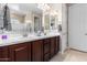 Bathroom with double sinks, dark wood cabinetry, and a glass-enclosed shower at 17111 S 180Th Ln, Goodyear, AZ 85338