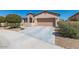 View of the driveway leading to a house with well-kept landscaping and a two-car garage at 17111 S 180Th Ln, Goodyear, AZ 85338