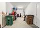 Cluttered garage interior showing storage solutions, trash cans, and water heater at 17111 S 180Th Ln, Goodyear, AZ 85338