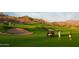 Scenic view of a golf course with players and golf carts, highlighting the recreational amenities at 17111 S 180Th Ln, Goodyear, AZ 85338
