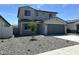 Inviting two-story home featuring a gray exterior, two-car garage, and low-maintenance gravel landscaping at 17245 W Corrine Dr, Surprise, AZ 85388