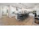 Modern kitchen with sleek white cabinets, stainless steel appliances, and a large island with seating at 17245 W Corrine Dr, Surprise, AZ 85388
