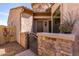 Inviting front entrance with an iron gate, stone accents, desert foliage, and a covered entry at 1847 N Red Clf, Mesa, AZ 85207