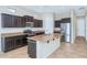 Stylish kitchen features dark cabinetry, stainless steel appliances, granite countertops, and a large island at 1847 N Red Clf, Mesa, AZ 85207