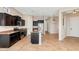 Open-concept kitchen with stainless steel appliances, dark wood cabinetry, and a central island at 1847 N Red Clf, Mesa, AZ 85207