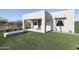 Modern home exterior with artificial grass, fire feature and covered patio at 1850 E Creek Canyon Rd, Phoenix, AZ 85086