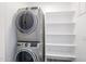 Laundry room with stackable washer/dryer and custom shelving for convenient storage and organization at 1850 E Creek Canyon Rd, Phoenix, AZ 85086