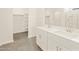 Elegant bathroom with dual sinks, tile flooring, and closet with built-in shelving at 19422 N Fiano Dr, Maricopa, AZ 85138