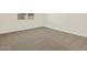 Bedroom with a neutral-toned carpet, white walls, and a bright window at 19422 N Fiano Dr, Maricopa, AZ 85138