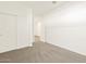 Well-lit bedroom with neutral carpet, closet doors, and a view into the hall at 19422 N Fiano Dr, Maricopa, AZ 85138