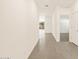 Bright hallway with grey tile leading to rooms with carpet and white trim at 19422 N Fiano Dr, Maricopa, AZ 85138