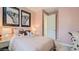 Cozy bedroom with pink walls, plush bedding, butterfly wall art, and a woven nightstand at 23081 E Saddle Way, Queen Creek, AZ 85142