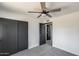 This bedroom includes a ceiling fan, carpeted floors, and a closet for easy storage at 3011 E John Cabot Dr, Phoenix, AZ 85032
