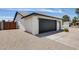 Spacious two-car garage with modern lighting fixtures and desert landscaping at 3011 E John Cabot Dr, Phoenix, AZ 85032