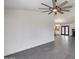 Spacious living area featuring gray tile flooring, modern ceiling fan, and views into the kitchen at 3011 E John Cabot Dr, Phoenix, AZ 85032