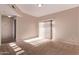 Bright living room with neutral carpeting, a sliding glass door, and fresh paint at 3434 E Baseline Rd # 214, Phoenix, AZ 85042