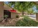 Exterior patio with a vibrant red umbrella, privacy fencing, and lush green grass at 3491 N Arizona Ave # 118, Chandler, AZ 85225