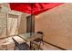 Back patio with table and chairs under a red umbrella at 3491 N Arizona Ave # 118, Chandler, AZ 85225