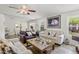 Bright living room featuring neutral-toned sofas, horse artwork, ceiling fan, and slate tile flooring at 3605 W Pecos Rd, Chandler, AZ 85226