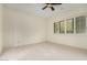 Bright bedroom with neutral carpet, ceiling fan, and plantation shutters at 36600 N Cave Creek Rd # C7, Cave Creek, AZ 85331