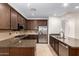 Well-lit kitchen featuring dark wood cabinets, stainless appliances and stone countertops at 36600 N Cave Creek Rd # C7, Cave Creek, AZ 85331