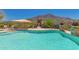 Community pool featuring desert mountain views, lounge chairs and an umbrella-shaded seating area at 36600 N Cave Creek Rd # C7, Cave Creek, AZ 85331