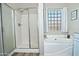 A bright bathroom with a glass-enclosed shower and a luxurious soaking tub with unique glass block window at 3812 W Carlos Ln, San Tan Valley, AZ 85144
