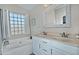 Well-lit bathroom featuring double sinks, framed mirror, and separate tub with glass block window at 3812 W Carlos Ln, San Tan Valley, AZ 85144